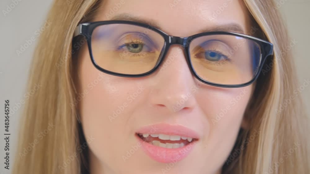 Beautiful blonde woman in glasses speaking on camera. Video portrait of young adult female talking on web camera with cheerful smile in closeup. Attractive person doing video call in 4k Beautiful blonde woman in glasses speaking on camera. Video portrait of young adult female talking on web camera with cheerful smile in closeup. Attractive person doing video call in 4k