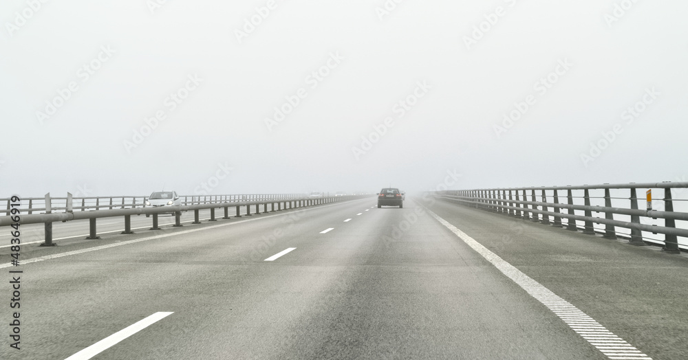 Naklejka premium The Oresund bridge over the sea connecting Sweden and Denmark is lost in the fog