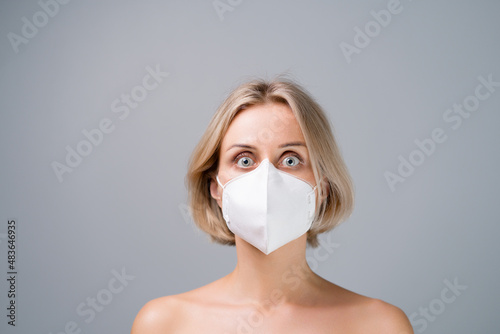 Portrait of a young woman in a medical mask on a grey background. photo