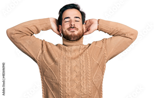 Young hispanic man wearing casual clothes relaxing and stretching, arms and hands behind head and neck smiling happy