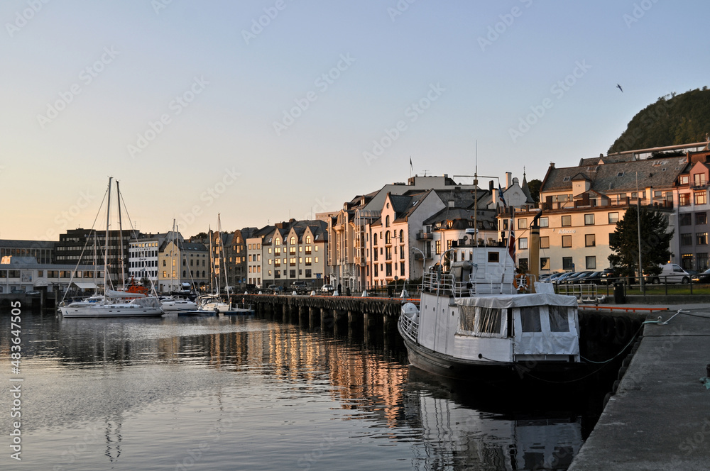 Fototapeta premium Alesund, Norway - 05 July 2011: Old colorful houses on the waterfront in Alesund, Norway in the evening at sunset.