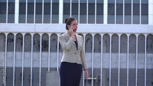 Businesswoman talking on the phone and walking off camera