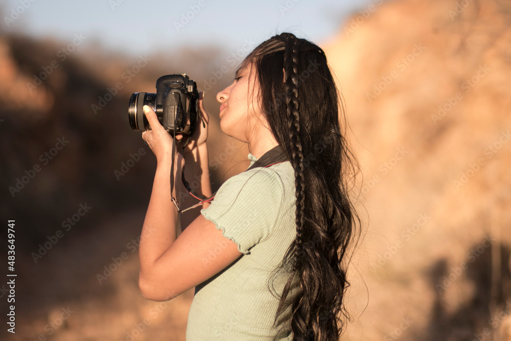 young female photography student looking at the screen of her camera