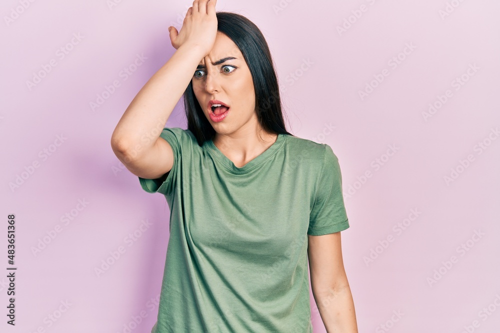 Beautiful woman with blue eyes wearing casual t shirt surprised with hand on head for mistake, remember error. forgot, bad memory concept. Beautiful woman with blue eyes wearing casual t shirt surprised with hand on head for mistake, remember error. forgot, bad memory concept.