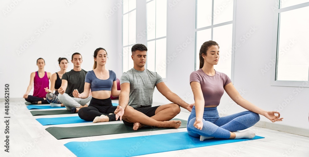 Group of young people concentrated training yoga at sport center. Group of young people concentrated training yoga at sport center.