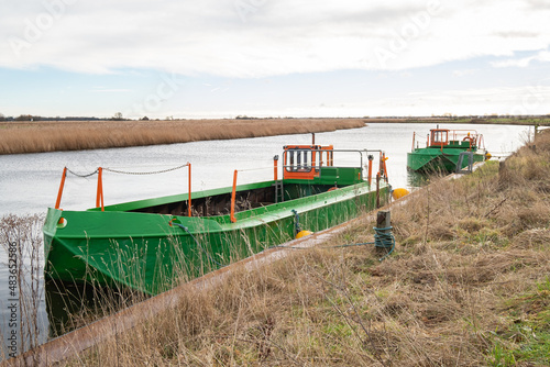 Generic green metal workboats moored on the river bank on the River Bure, Norfolk Broads photo