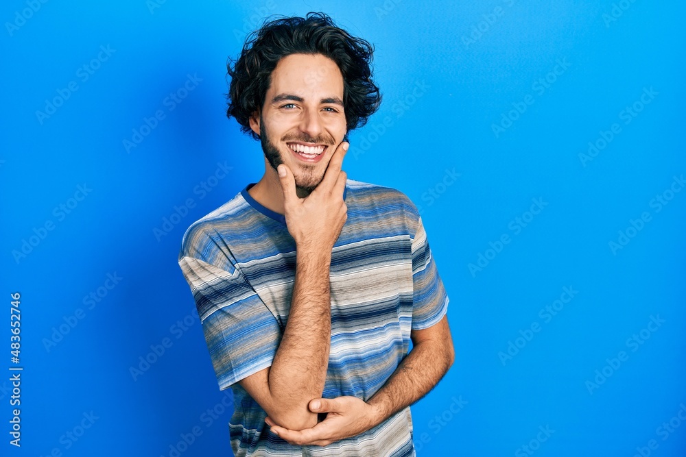 Handsome hispanic man wearing casual clothes over pink background looking confident at the camera smiling with crossed arms and hand raised on chin. thinking positive. Handsome hispanic man wearing casual clothes over pink background looking confident at the camera smiling with crossed arms and hand raised on chin. thinking positive.
