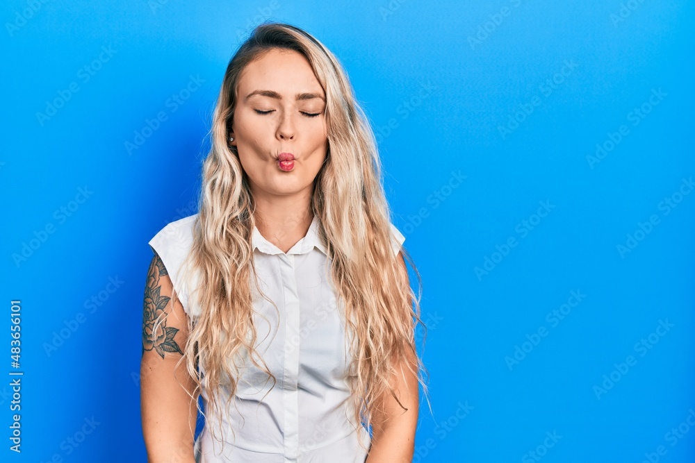 Beautiful young blonde woman wearing casual white shirt making fish face with lips, crazy and comical gesture. funny expression. Beautiful young blonde woman wearing casual white shirt making fish face with lips, crazy and comical gesture. funny expression.