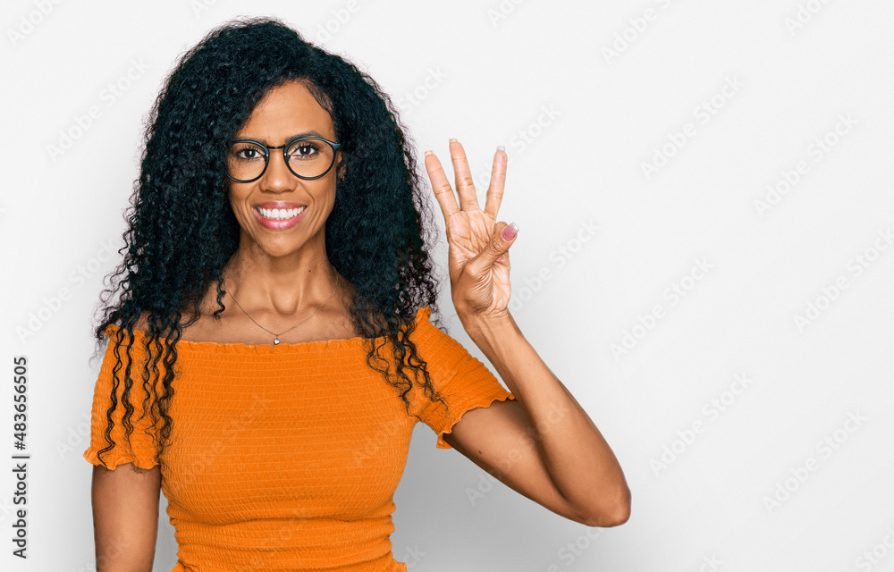 Middle age african american woman wearing casual clothes and glasses showing and pointing up with fingers number three while smiling confident and happy. Middle age african american woman wearing casual clothes and glasses showing and pointing up with fingers number three while smiling confident and happy.
