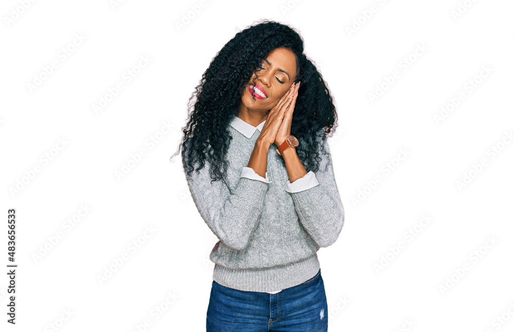 Middle age african american woman wearing casual clothes sleeping tired dreaming and posing with hands together while smiling with closed eyes. Middle age african american woman wearing casual clothes sleeping tired dreaming and posing with hands together while smiling with closed eyes.