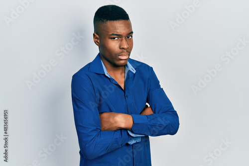 Young african american man with arms crossed gesture clueless and confused expression. doubt concept.