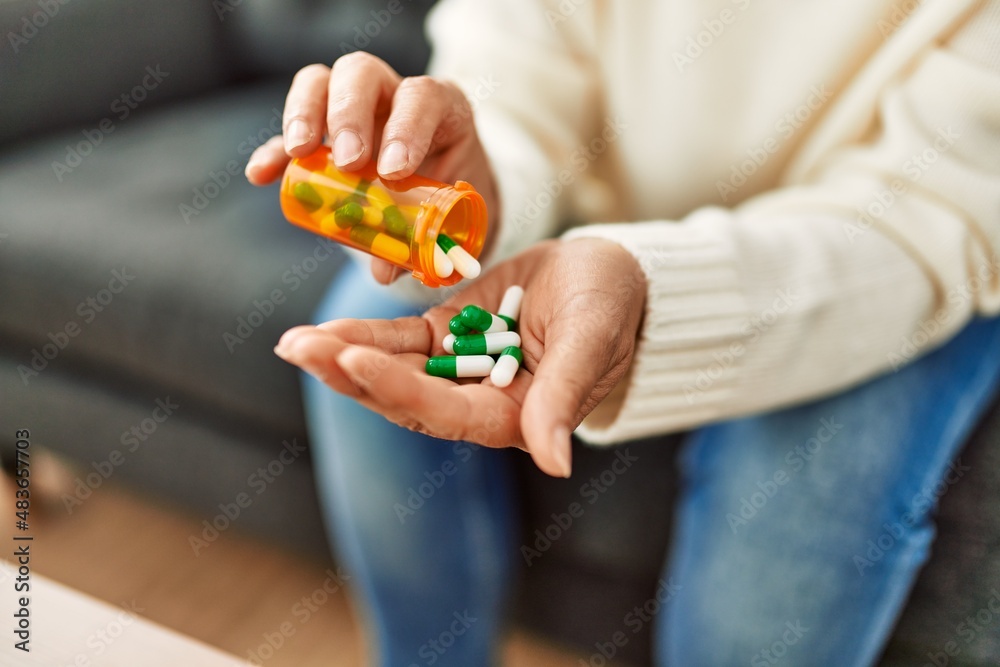 Middle age hispanic woman taking pills at home Middle age hispanic woman taking pills at home