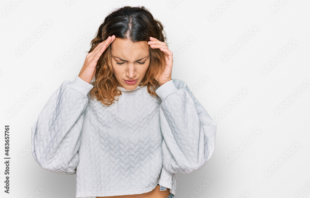 Beautiful young caucasian woman wearing casual winter sweater with hand on head for pain in head because stress. suffering migraine. Beautiful young caucasian woman wearing casual winter sweater with hand on head for pain in head because stress. suffering migraine.