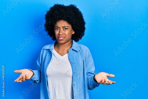 Young african american woman wearing casual clothes clueless and confused with open arms, no idea concept.