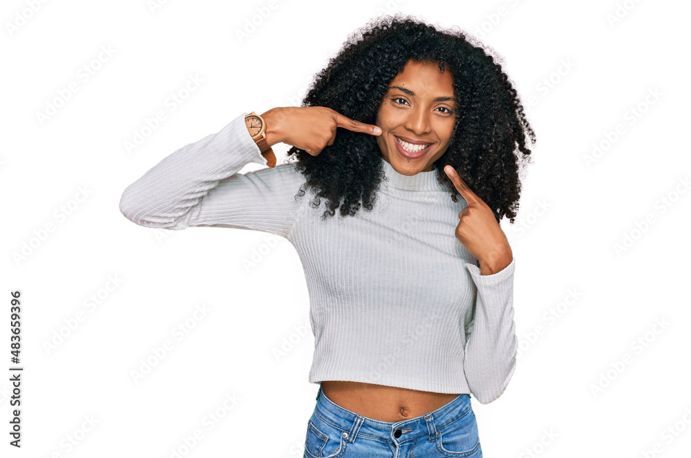 Young african american girl wearing casual clothes smiling cheerful showing and pointing with fingers teeth and mouth. dental health concept. Young african american girl wearing casual clothes smiling cheerful showing and pointing with fingers teeth and mouth. dental health concept.