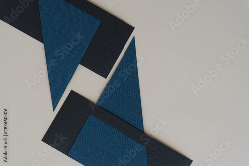 abstract geometric paper background in blue and black on gray-beige