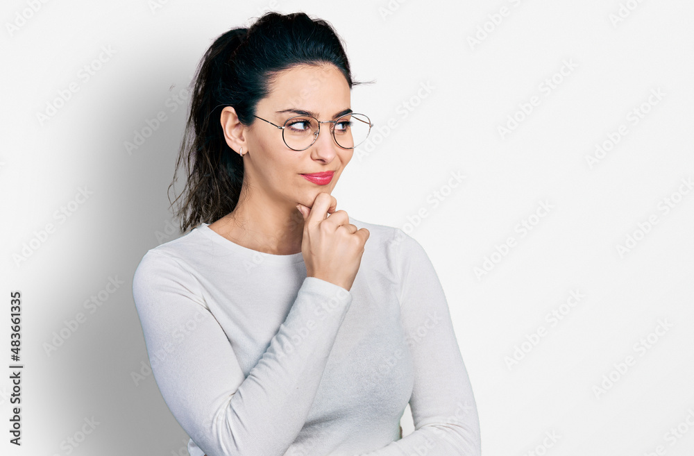Young hispanic woman wearing casual clothes with hand on chin thinking about question, pensive expression. smiling with thoughtful face. doubt concept. Young hispanic woman wearing casual clothes with hand on chin thinking about question, pensive expression. smiling with thoughtful face. doubt concept.