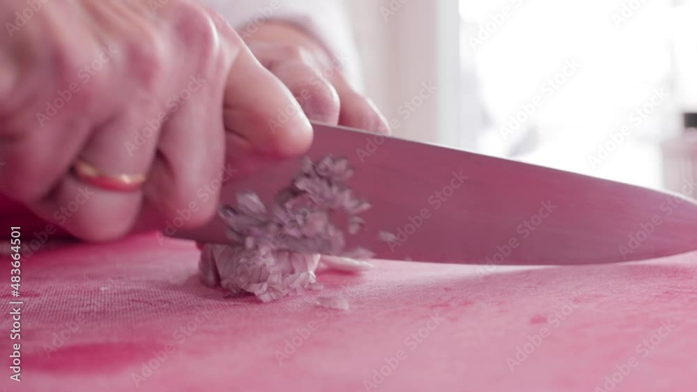 chef cutting red onion in slow motion