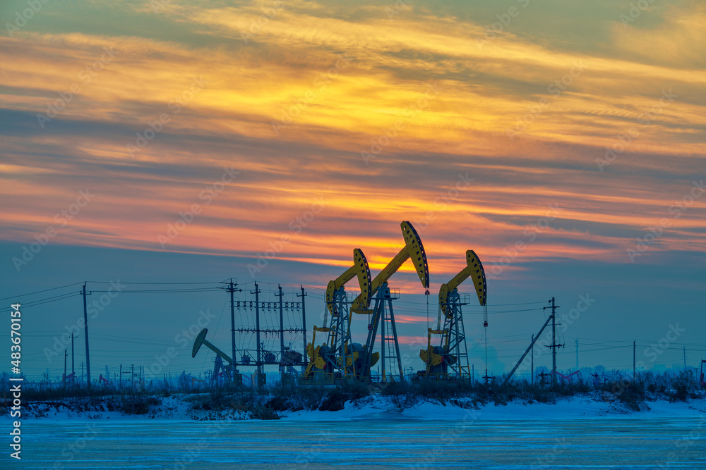 The oil pumping units in lakeside in winter in Daqing oil fields, China.