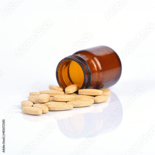 Two size of vitamin C bottle and pill with reflection