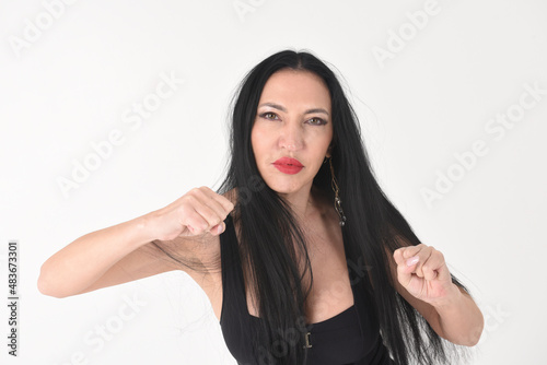 Fotografie Portrait of a beautiful brunette woman in an explosive fighting pose ready to fi