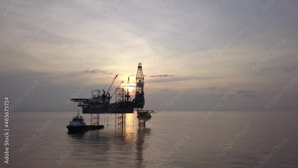 Aerial view from a drone of an offshore jack up rig at the offshore location during sunrise time Aerial view from a drone of an offshore jack up rig at the offshore location during sunrise time