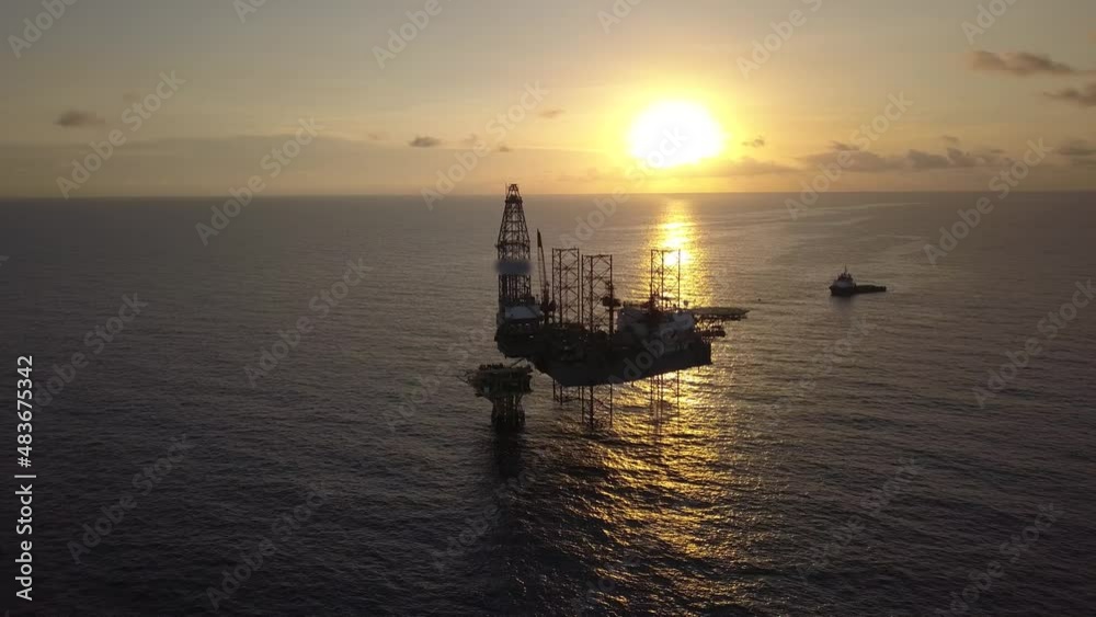 Aerial view from a drone of an offshore jack up rig at the offshore location during sunrise time