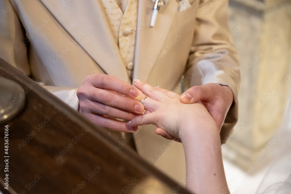 Obraz premium The groom is wearing a ring on the ring finger of the bride