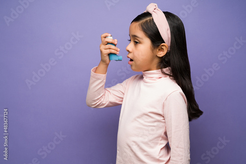 Sick little girl having an asthma attack photo