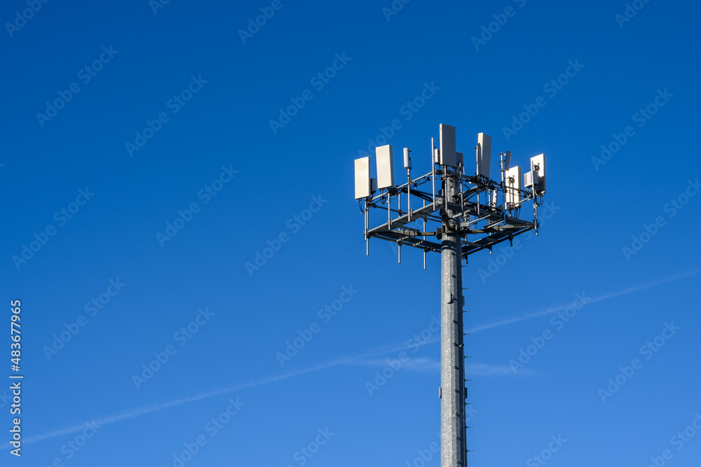 Fototapeta premium Closeup of wireless cell site antennas on a monopole tower against a clear blue sky 