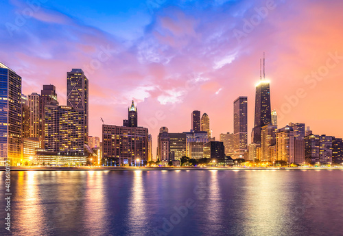 Chicago Downtown at dusk with warm color sky. City lights reflected in the Lake Michigan