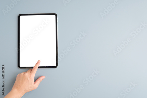 Hand touch digital tablet with blank on screen isolated on gray background, banner for template, mock up, topview, flat lay, communication technology