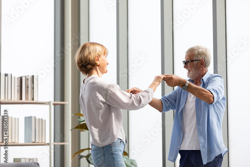 senior couple, elderly man and woman dancing together at home