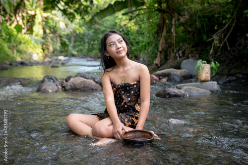 Beautiful young Asian girl rests and bathes in the river