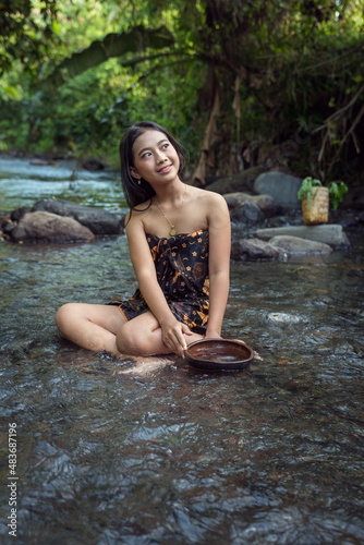 Beautiful young Asian girl rests and bathes in the river © Ace Mason