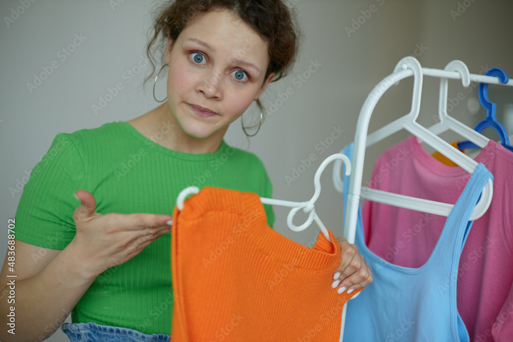 funny girl ironing clothes on a hanger wardrobe light background unaltered funny girl ironing clothes on a hanger wardrobe light background unaltered