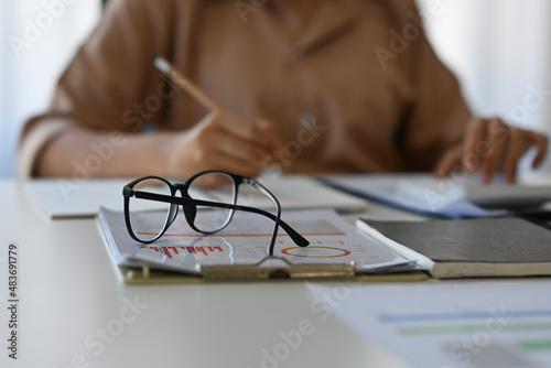 Close up with Glasses of female accountant or banker while making calculations, Savings, finances and economy concept.