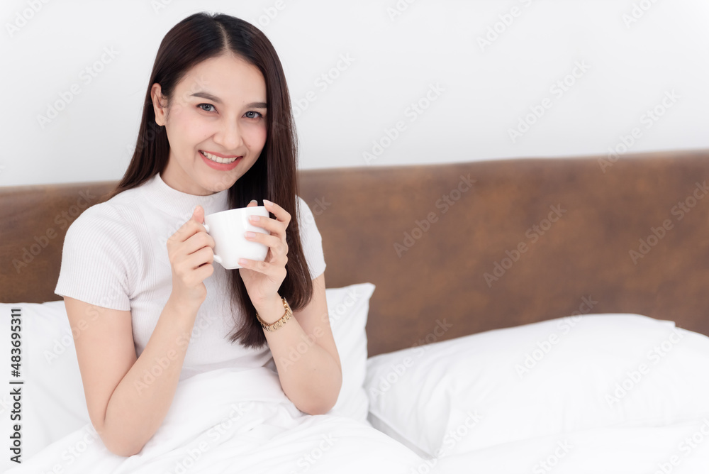 Beautiful asian woman Drinking coffee And happy smile On the bed in the white bedroom Beautiful asian woman Drinking coffee And happy smile On the bed in the white bedroom