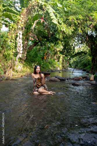 Portrait of young girl in river, woman posing on the water 