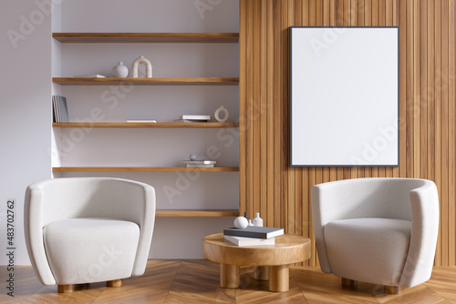 Bright living room interior with empty white poster, armchairs, shelves © ImageFlow