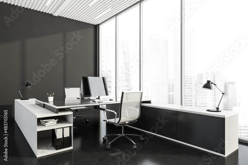 Corner view of dark grey office room interior with two workplaces and panoramic windows © ImageFlow