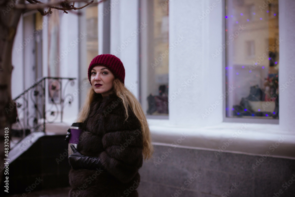 portrait of a white girl in winter in a fur coat who walks through the streets of the city portrait of a white girl in winter in a fur coat who walks through the streets of the city