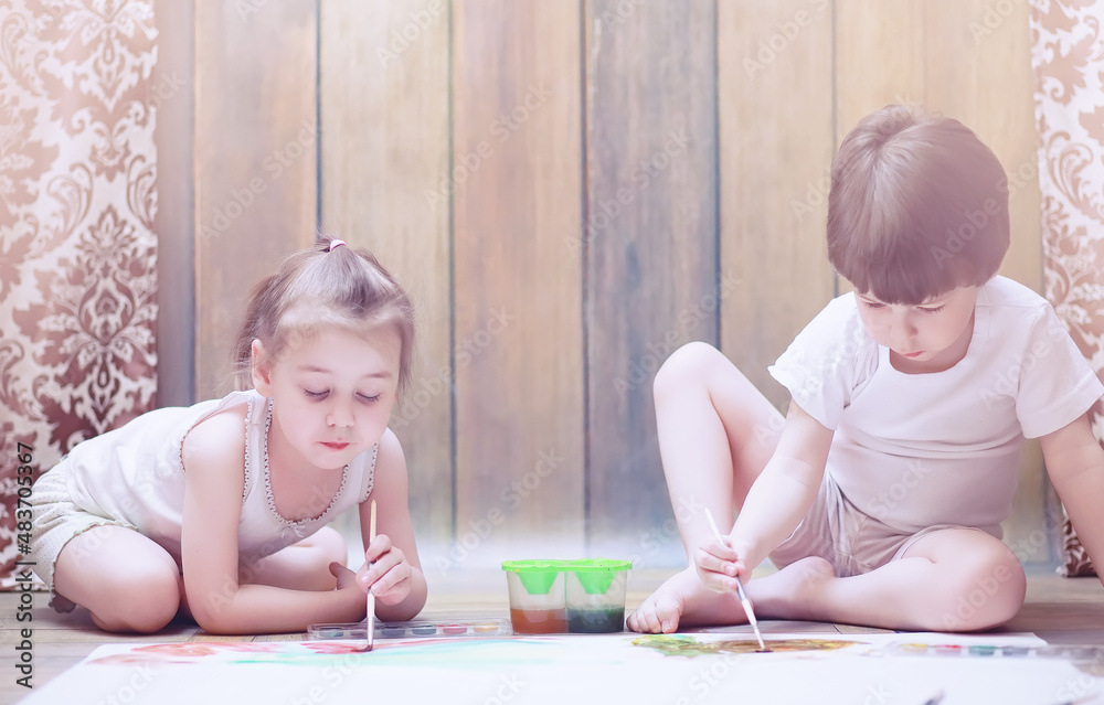 Little children paint on a large sheet of paper Little children paint on a large sheet of paper