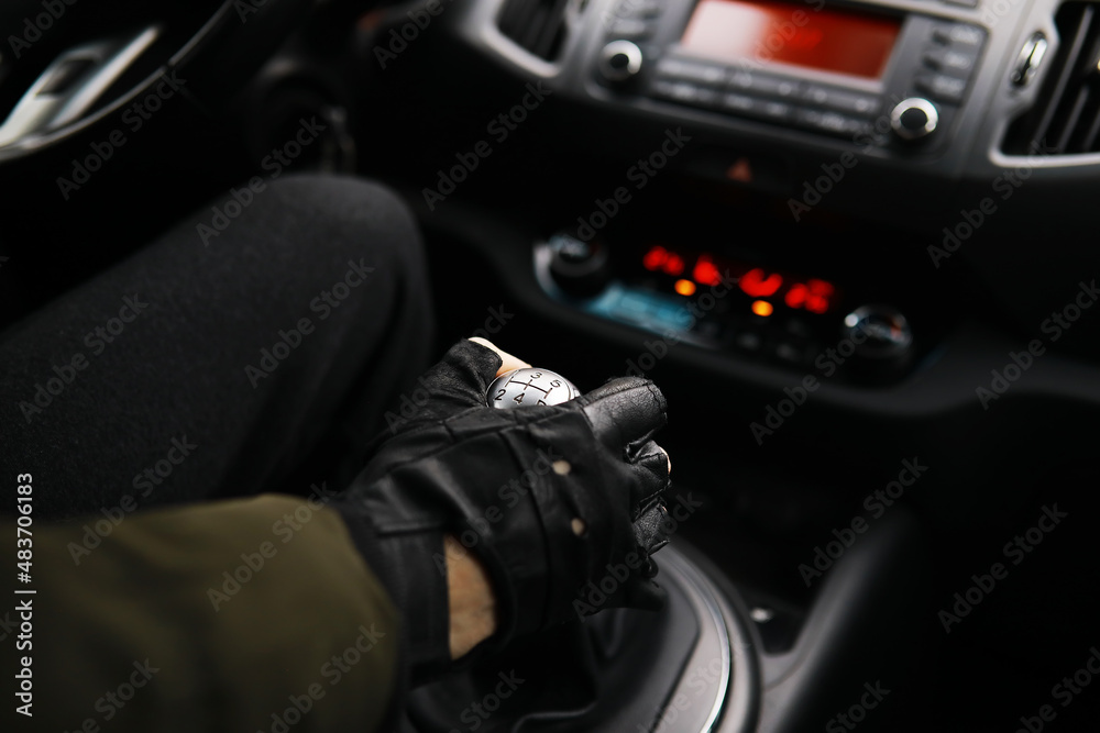 Hand on the car gear knob. The driver switches the speed in the car. Hand on gear lever.