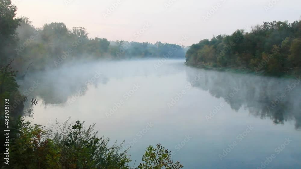 Smoke on the water. Fog floats over the river in the early morning at dawn. A beautiful lake on the background of the green forest. Fascinating miracles of nature. Water surface. Copy space for text Smoke on the water. Fog floats over the river in the early morning at dawn. A beautiful lake on the background of the green forest. Fascinating miracles of nature. Water surface. Copy space for text