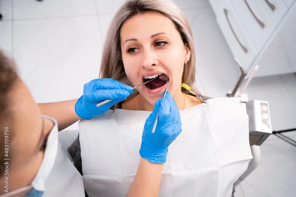 professional dentist examines and treats damaged teeth using special dental instruments, medical equipment. Dental hygiene and health concept. professional dentist examines and treats damaged teeth using special dental instruments, medical equipment. Dental hygiene and health concept.