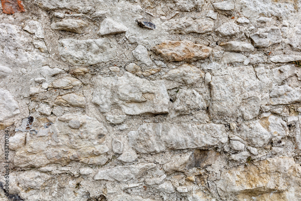 Fragment of an old gray stone wall old gray masonry