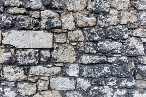 Fragment of an old gray stone wall old gray masonry