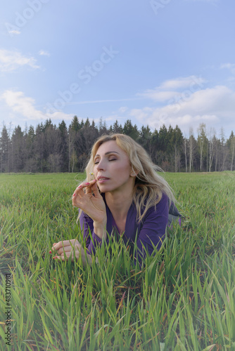 Beautiful blond woman enjoying the Sun on the meadow