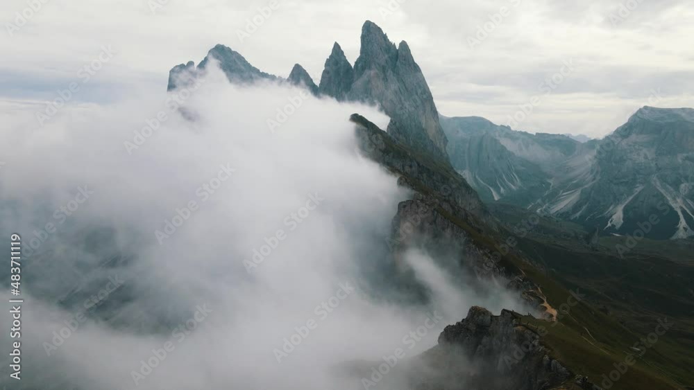 Three impressive mountain peaks called Drei Zinnen with no clouds on the Trentino side and more and more clouds on the Veneto side. High angle aerial drone shot Three impressive mountain peaks called Drei Zinnen with no clouds on the Trentino side and more and more clouds on the Veneto side. High angle aerial drone shot